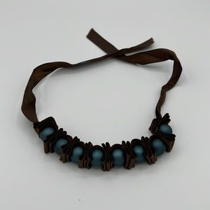 Brown ribbon bracelet with blue beads